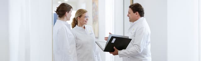 Dieses Bild zeigt Frau Dr. Jennifer Quist und Herrn Dr. Sven Quist beim Gespräch im Gang.