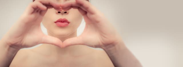 Frau formt mit Händen ein Herz