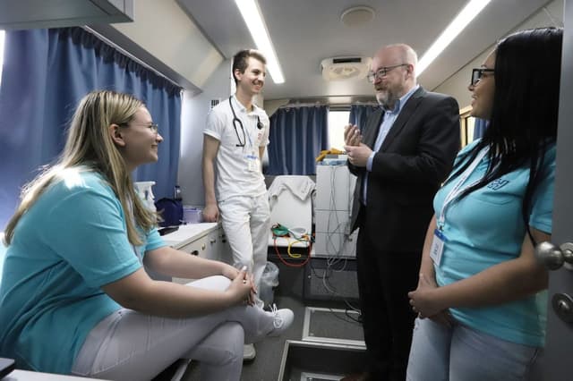 A busz belsejében: a főigazgató kötetlenül beszélget a vizsgálatokat végző fiatal munkatársakkal a modern berendezésű járművön.