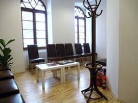 Blick in das Wartezimmer der Praxis mit den bequemen schwarzen Stühlen