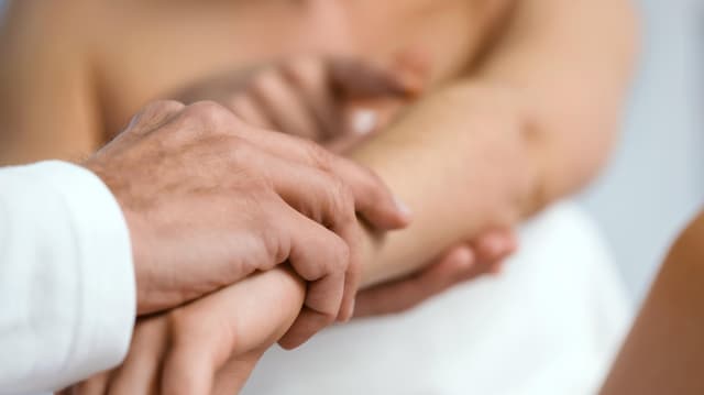 Nahaufnahme von Händen bei einer allgemeinen dermatologischen Untersuchung.
