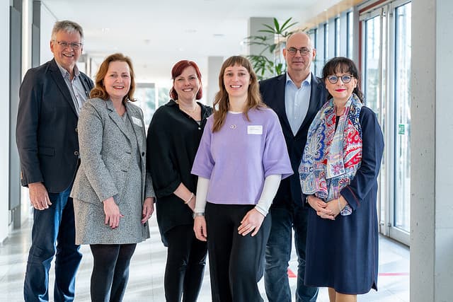 Gruppenbild: Vier Organisator:innen des Geriatrietags 2026 der Universitätsmedizin Halle, die Dekanin der Medizinischen Fakultät der MLU und die Keynote-Speakerin stehen in einem Gang.   Gruppenbild: Vier Organisator:innen des Geriatrietags 2026 der Universitätsmedizin Halle, die Dekanin der Medizinischen Fakultät der MLU und die Keynote-Speakerin stehen in einem Gang. 